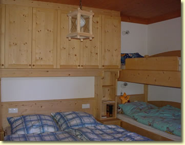 Schlafzimmer mit Einbauschränken, Doppelbett und Stockbett